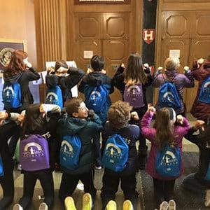 Group of 7th graders showing their drawstring bags on their backs