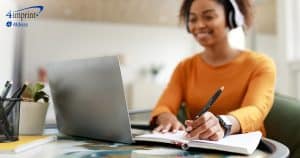 Smiling woman writing in a notebook.