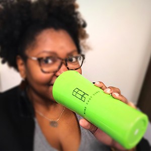 Person drinking out of a lime green tumblr