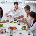 5 people sitting at a table eating a healthy meal - it is a 3 minute read to read the blog entitled - Best promotional giveaways for a healthy start to the year