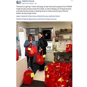 Two volunteers posing with their red canvas grocery bags