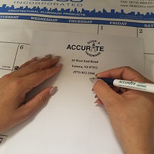 Hand holding a pen next to paper