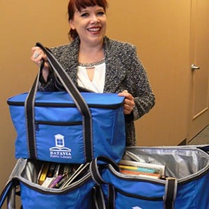 A woman holds blue Utility 36-Can Cooler Totes.