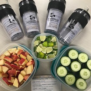 Refresh Pebble Tumblers arranged on a table with cut up fruit and vegetables. 