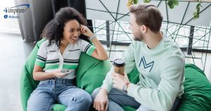 Two smiling friends sitting on green bean bags.