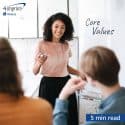 Woman presenting to an audience. “Core values” is written on a whiteboard