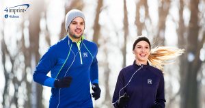 Two people running outdoors in fitness gear.