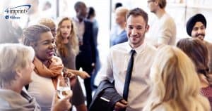 Colleagues standing around talking with drinks in hand.