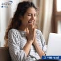 Woman looking at computer screen and laughing.