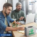 Guy sitting at table looking at laptop with retro lunchbox