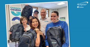 Smiling group of people holding branded backpacks