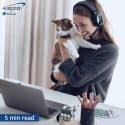 Woman in home office holding cat while video chatting.