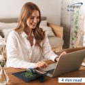 Woman working on laptop computer in home office setting.