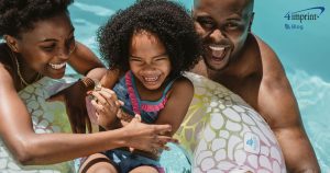 Parents and child playing in swimming pool.