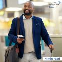 Smiling man walking through an airport.