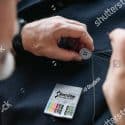 A person sews a button onto a jacket using a sewing kit.