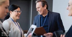 A professional man and woman attend a trade show.