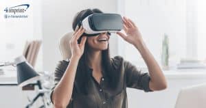 Professional woman at desk smiling while looking through VR glasses.