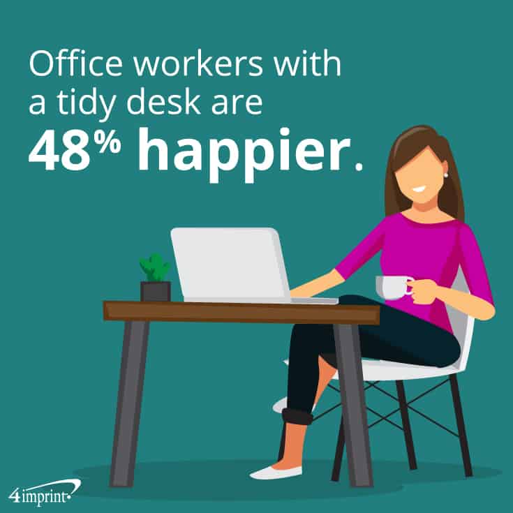 Smiling woman sitting at tidy workspace with a laptop.