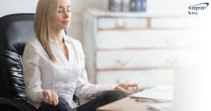 Woman meditating at desk.