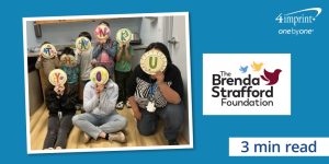 Eight people holding decorated paper plates in front of their faces. Each plate contains a letter to spell the phrase, “thank you."