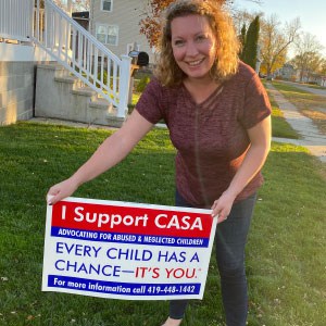  CASA supporters showing off their marketing yard signs.