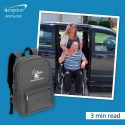 A woman and man in wheelchair smiling in front of minivan