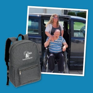 A woman and man in wheelchair smiling in front of minivan