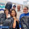 Smiling group of people carrying branded backpacks.
