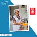 Ethiopian woman with a whisk and bowl in a kitchen.