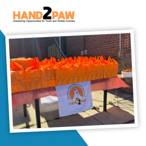 A table filled with brightly colored orange gift bags.