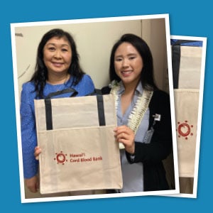 Two Hawai’i Cord Blood Bank staff displaying a branded reusable grocery bag. 