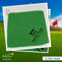Hearth Place Cancer Support Centre branded golf towel with a golf course in the background. 2 minute read