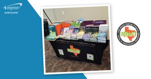 A branded table holding boxes of children’s books.