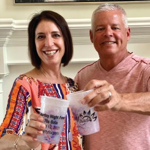 Two adults clinking their branded cups together.