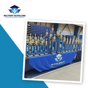 An array of trophies on a table with a branded table cover.