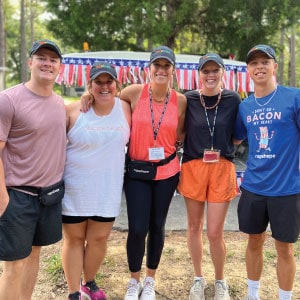 Group of camp volunteers wearing baseball caps with a logo.