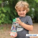 Smiling young boy holds clear branded water bottle with green lid.
