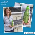 Woman holding a green water bottle with a logo.