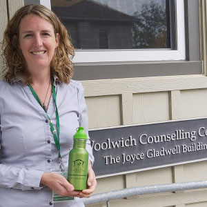 Woman holding a green water bottle with a logo.