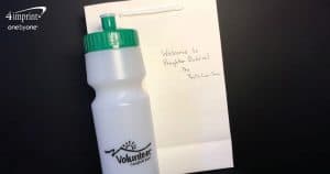 A promotional water bottle and note that says, "Welcome to Brighter Buddies."