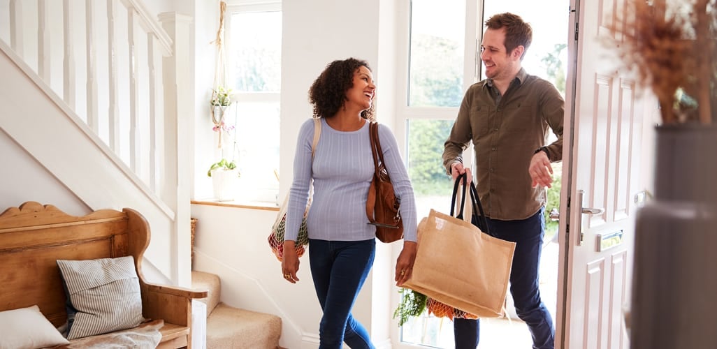 Man and woman smiling and holding tote bags