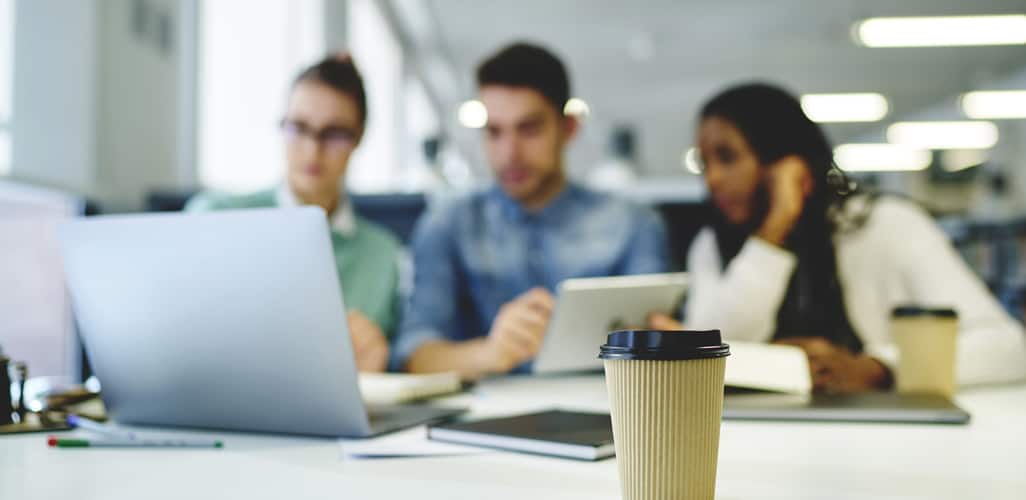 Workers in an office with recyclable coffee cup