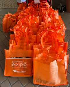 Two rows of bright orange swag bags.