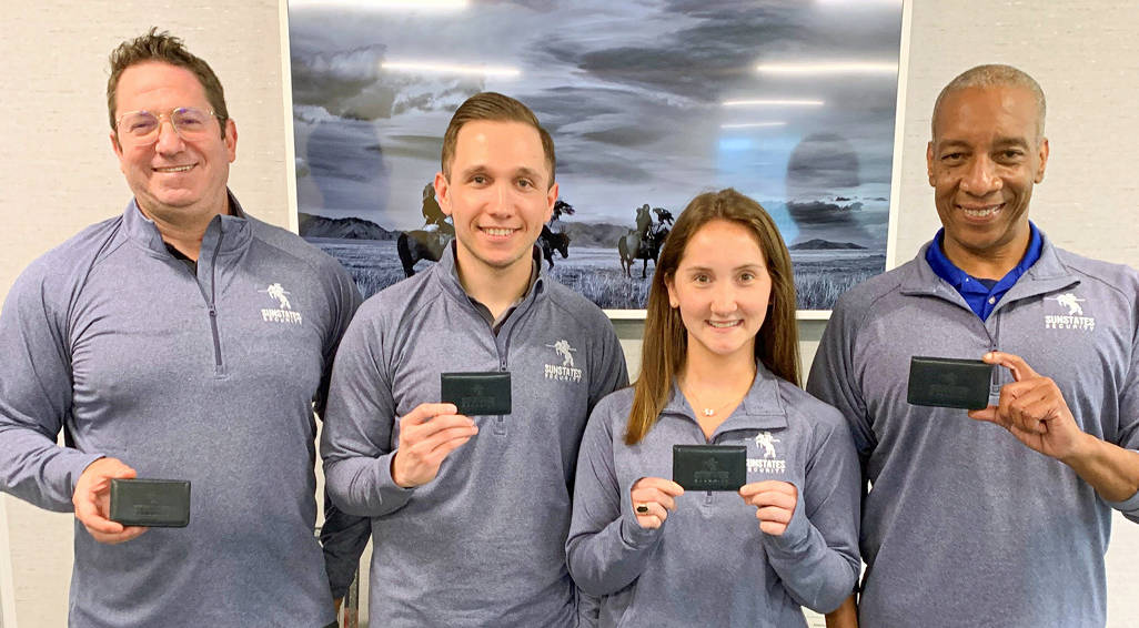 4 leaders at Sunstates Security holding their branded business card holders.
