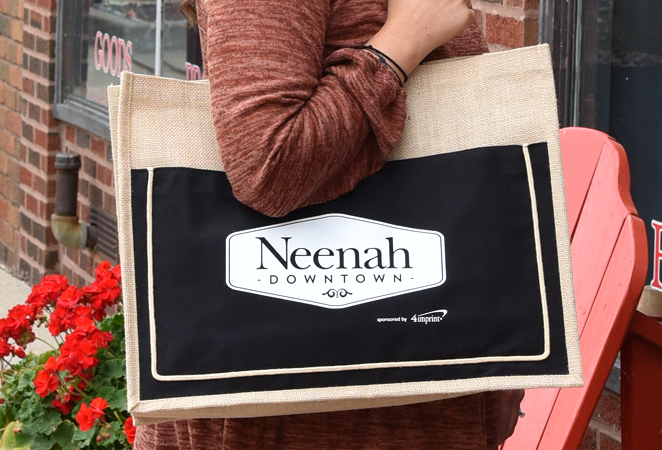 Person carrying branded event tote over their sholder