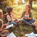 Group of kids and one adult sitting in discussion circle outside with notebooks and pens - 4 min read