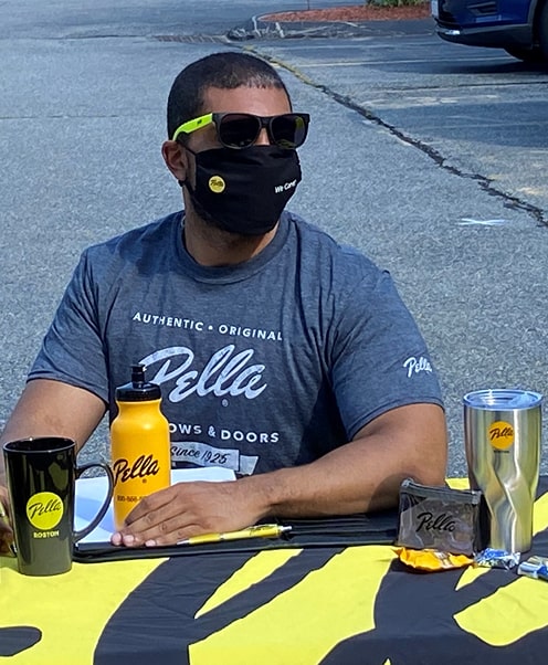 A Pella employee with a table full of promotional items
