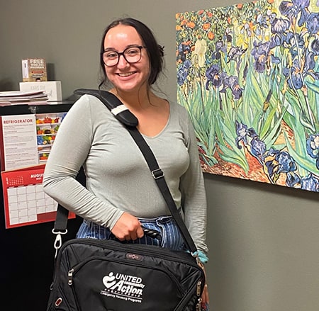 An employee holds her branded messenger bag.