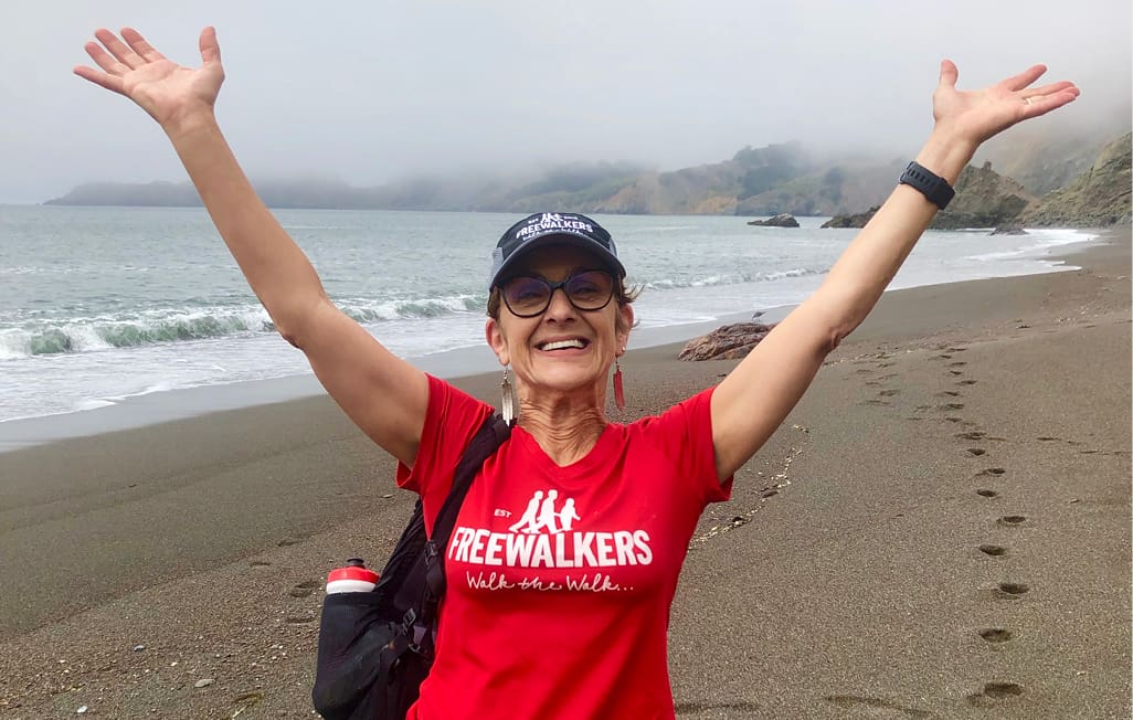 A woman stands on the beach in promo clothing.